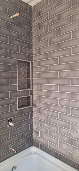 Gray subway tile shower with niche